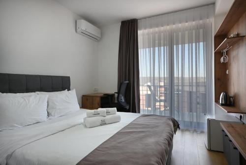 a bedroom with a large bed with a large window at Lakeview Apartments in Veles