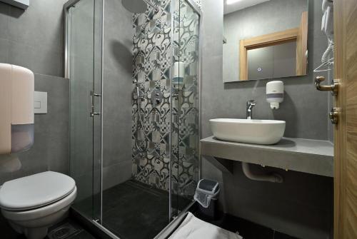 a bathroom with a toilet and a sink and a shower at Lakeview Apartments in Veles