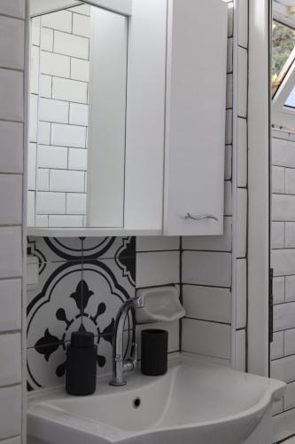 a white bathroom with a sink and a mirror at Sun Rose Pansiyon in Pamukkale