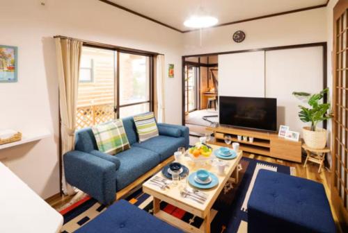 a living room with a blue couch and a table at Wave House Kujukuri Fujishita Near Kujukuri beach- Self Check-In Only in Kujukuri