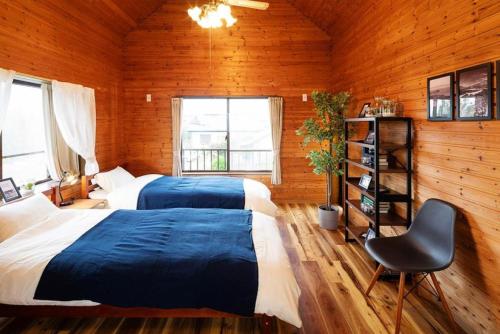 two beds in a room with wooden walls at Wave House Kujukuri Fujishita Near Kujukuri beach- Self Check-In Only in Kujukuri