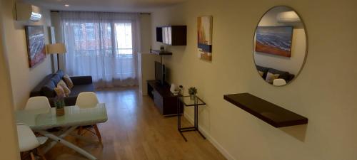 a living room with a table and a mirror at El Ritual Apartamento in Tudela