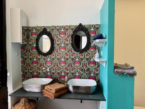 a bathroom with two sinks and two mirrors at Tour XIIIe siècle, vue mer, Cap Corse in Brando