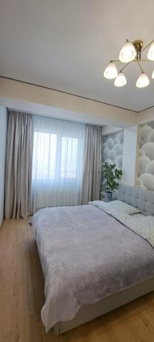 a large bed in a bedroom with a window at SkyHouse&PrivateGarage in Chişinău