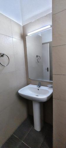 a bathroom with a white sink and a mirror at Shanzu Beach Homes 105 in Mombasa