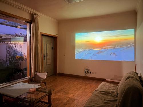 a living room with a large painting on the wall at Kulikuli Boy's Inn in Lijiang