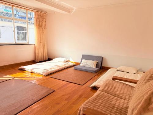 a room with two beds and a window at Kulikuli Boy's Inn in Lijiang
