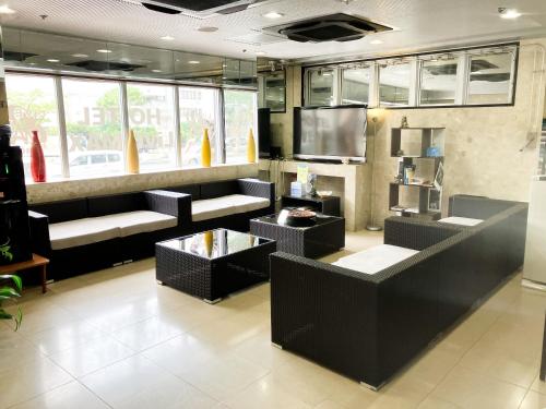 ein Restaurant mit Sofas und Tischen in einem Raum in der Unterkunft HOTEL LiVEMAX BUDGET Naha in Naha