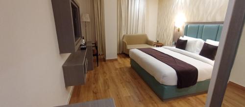 a hotel room with a large bed and a television at AairHotel in Karnal