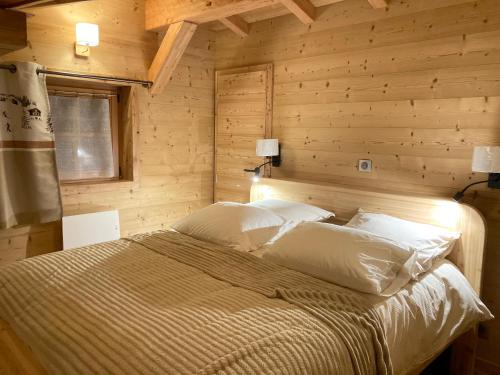 a bedroom with a bed in a wooden wall at Vertigo in Puy-Saint-Pierre
