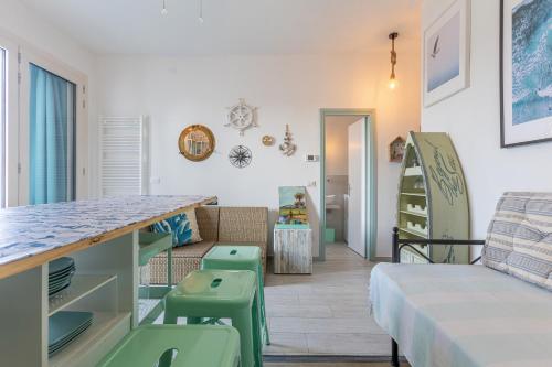 a room with a bed and a table and chairs at GuestHost - Parco del Sole Residence Flat with Terrace in lido degli scacchi