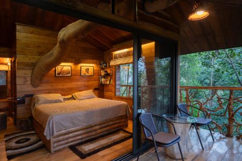 a bedroom with a bed and a table and chairs at Tranquil Resort - Blusalzz Collection, Wayanad - Kerala in Ambalavayal