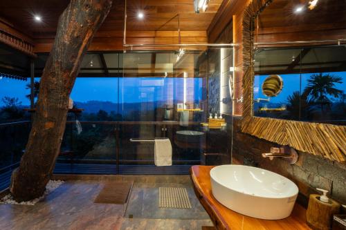 a bathroom with a large glass shower and a sink at Tranquil Resort - Blusalzz Collection, Wayanad - Kerala in Ambalavayal