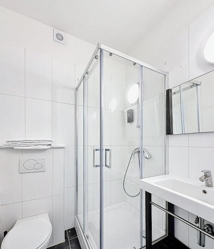 a bathroom with a shower and a toilet and a sink at Keyless Hotel - Van Gaver in Brussels
