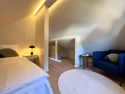 a bedroom with a bed and a blue couch at Odda Gangdal Apartments in Odda