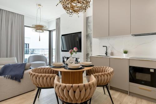 a kitchen and living room with a table and chairs at Sol Marina Apartment by Solarento in Wiślinka