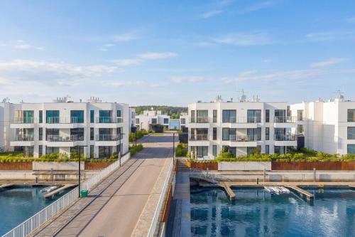 a row of apartment buildings next to a body of water at Sol Marina Apartment by Solarento in Wiślinka
