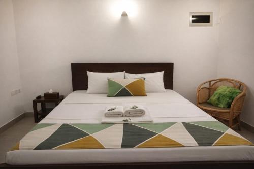 a bedroom with a bed with two towels on it at Villa Mango in Negombo
