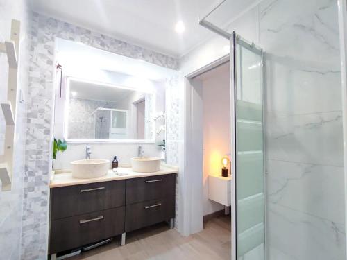 a bathroom with two sinks and a glass shower at Vilamoura Condo facing the pool by Algarve Dream Holidays in Quarteira