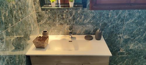 a bathroom with a sink with a basket on it at A&Bpikermistudios in Pikérmion