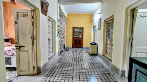 an empty hallway with a door and a tile floor at Maya's Crest in Howrah