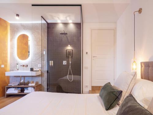a bedroom with a shower and a bed and a sink at Tenuta Asmara Luxury Resort in San Miniato