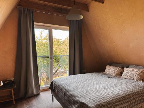 a bedroom with a bed and a large window at Mulberynas in Stakliškės