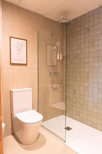 a bathroom with a toilet and a glass shower at Ohtels Les Oliveres in Perelló