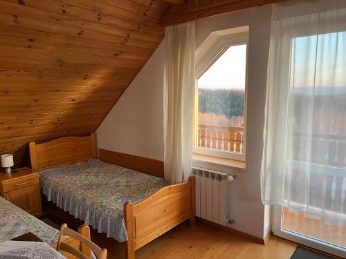 a bedroom with a bed and a large window at Podkamiencem in Odrzykoń