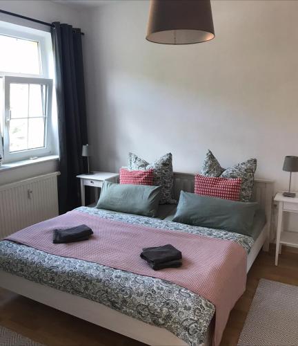 a bedroom with a bed with two towels on it at Ferienwohnung am Wald in Sebnitz