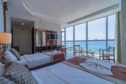 a bedroom with two beds and a view of the ocean at Grand Barhan Hotel Alanya in Alanya