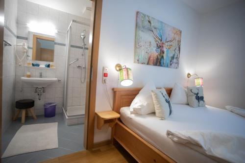 a bathroom with a bed and a shower and a sink at Frühstückspension Josefinum in Bad Aussee