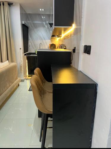a kitchen with a counter with a chair and a sink at TheEliteHavenshortlet in Lekki