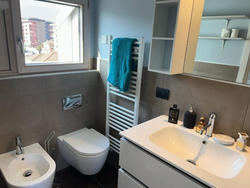 a bathroom with a sink and a toilet and a window at Attico Don Minzoni in Intra