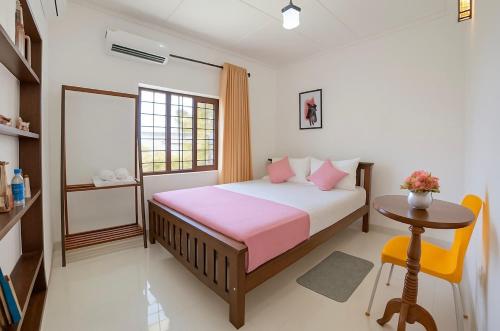 a bedroom with a bed and a table and a window at Emerald Hill Bungalow in Kandy