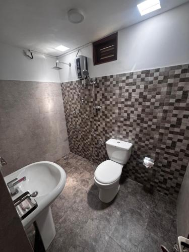 a bathroom with a toilet and a sink at Emerald Hill Bungalow in Kandy