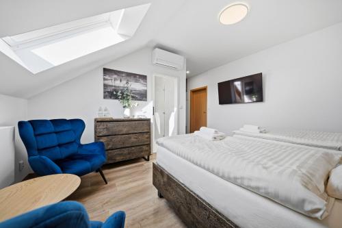 a bedroom with a bed and a blue chair at Blatenský dvůr in Pardubice