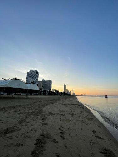 a view of a beach with buildings in the background at HOOD Hostel Jomtien in Jomtien Beach