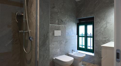 ein Badezimmer mit Dusche, Toilette und Waschbecken in der Unterkunft Da Cuful in Reana del Roiale