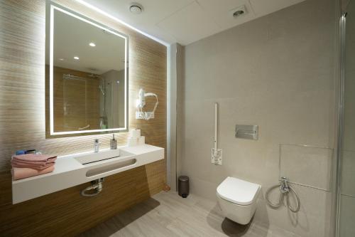 a bathroom with a sink and a toilet and a mirror at Mimi's Apartment in En Corts in Valencia