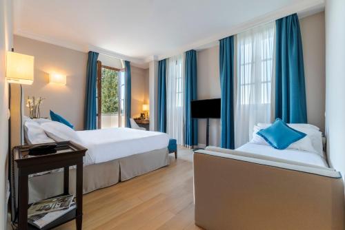 a hotel room with two beds and a table at Villa Neroli - Place of Charme in Florence