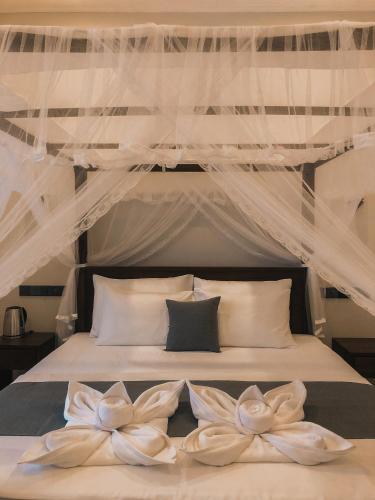 a bedroom with a bed with a canopy at Chamindu Villa Matara in Matara