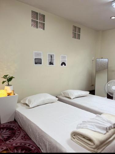 two beds sitting next to each other in a room at KODO Guest House in Nathon Bay
