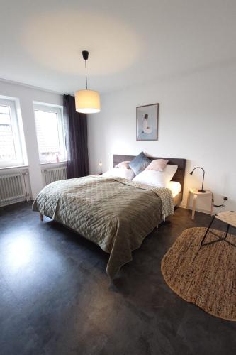 a bedroom with a large bed and a rug at Wohnen am Klinikum 2 in Oldenburg