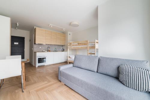 a living room with a couch and a kitchen at Luboń Urban Nest Studio by BookingHost in Luboń