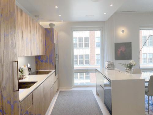 a kitchen with white counters and a large window at Luxury City Seafront Apartment with Balcony in Helsinki