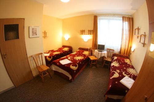 a hotel room with two beds and a table at Hotel Daisy Budget in Krakow