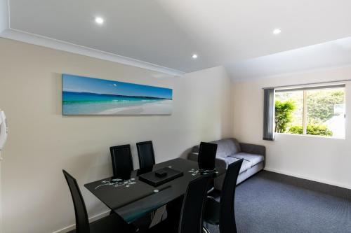a dining room with a table and chairs and a window at Dolphin Shores in Vincentia