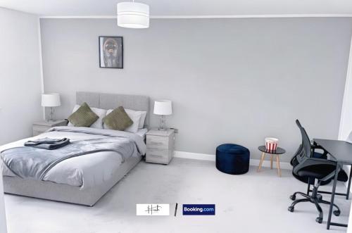 a bedroom with a bed and a desk and a chair at Luxury two bedroom apartment with parking games and fast unlimited Wi-Fi by Hush Haven Homes Serviced Accommodation in Hull