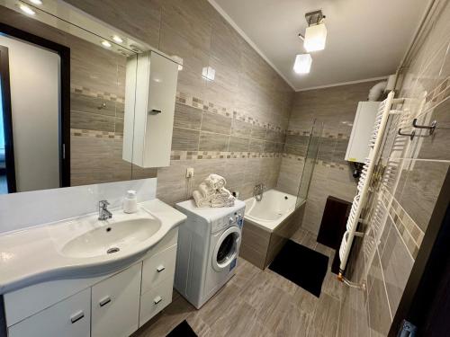 a bathroom with a washing machine and a sink at Misa Home in Nyíregyháza